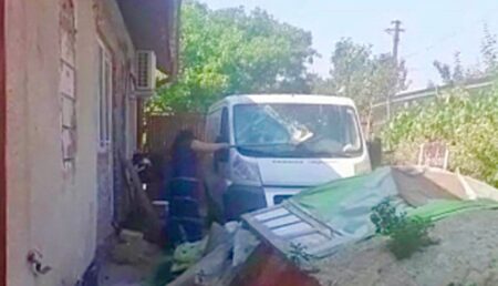 Argeș: O femeie s-a pus cu cazmaua pe geamurile casei și pe mașina familiei